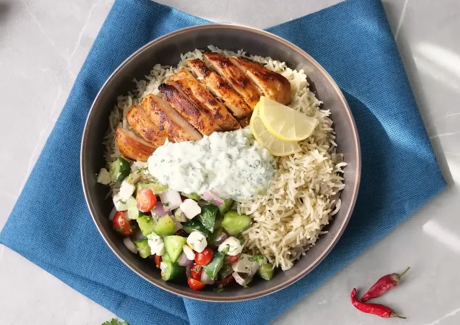 Garlic yogurt chicken and rice bowl with kale, roasted radishes, onions, lentils, and creamy tahini garlic sauce