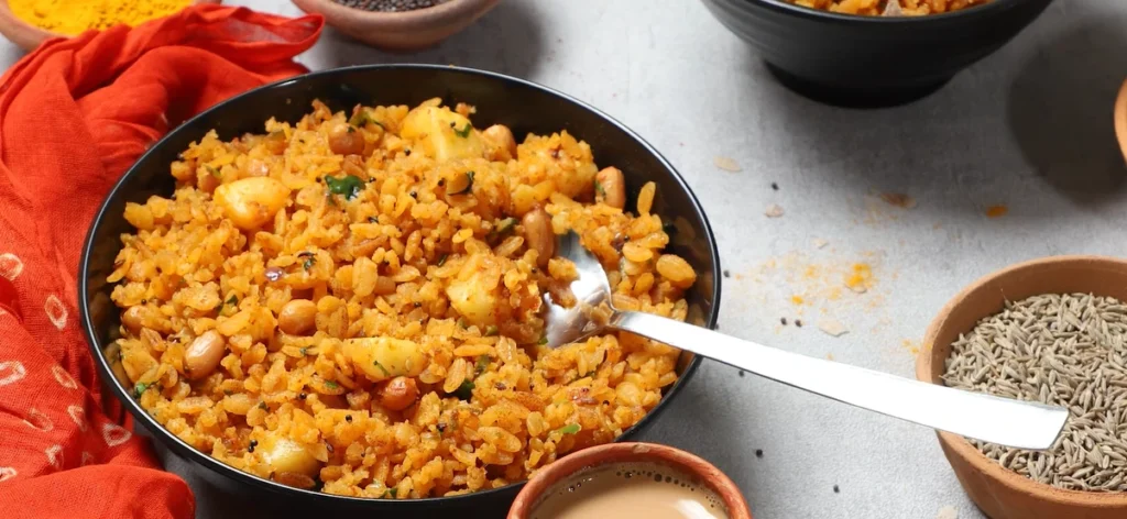 Red rice poha with peanuts, potato, onion, and curry leaves for an easy breakfast