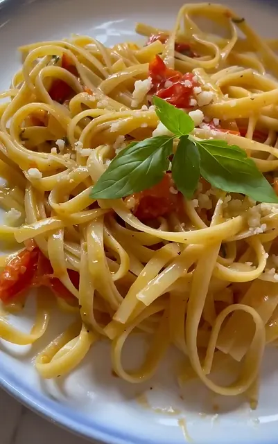 Cherry tomato pasta with Parmesan and fresh basil in a skillet