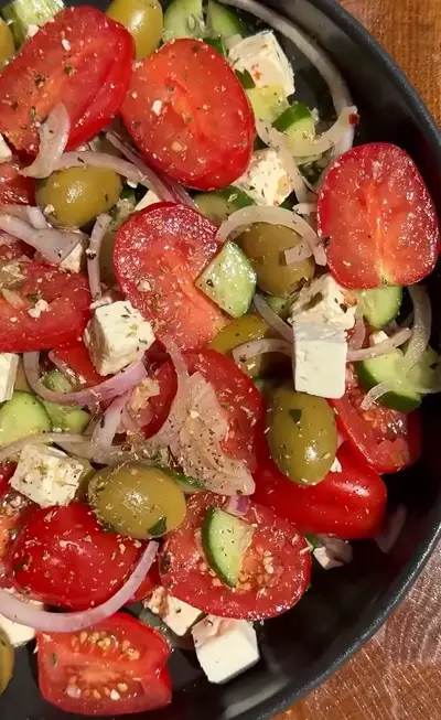 Classic Greek salad with tomatoes, cucumber, feta, olives, red onion, oregano, and olive oil.