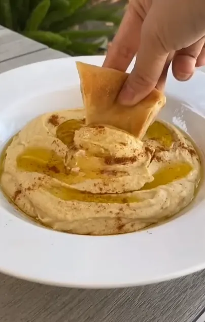 Creamy Lebanese-style hummus with tahini, olive oil, chickpeas, and warm pita.