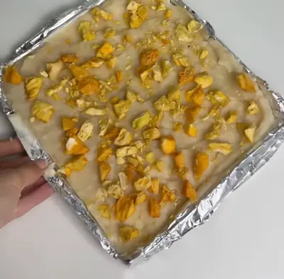 Lemon pineapple yogurt bark topped with pineapple, kiwi, blueberries, coconut flakes, almonds, and lemon zest