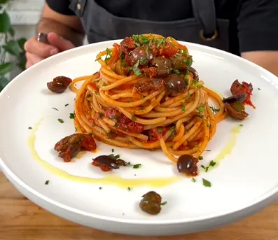 Tuna pasta puttanesca with tomatoes, olives, capers, garlic, and Parmesan.