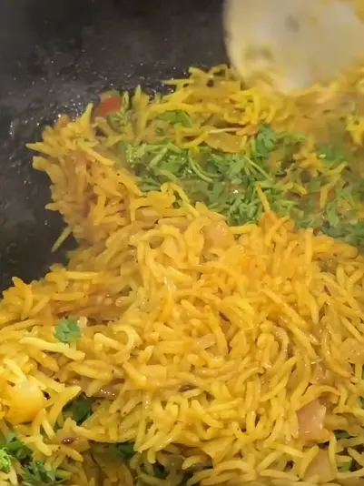 Spiced bottle gourd rice with grated lauki, semi-brown rice, onion, tomato, herbs, and Indian spices in a lunch box