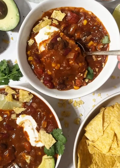 Vegan chili non-carne soup with beans, butternut squash, brown rice, tomatoes, and crispy tortilla strips