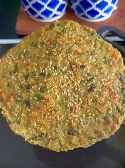 Jowar flatbread rolls filled with thick yogurt, cabbage, carrot, and bell pepper, cut in half for a healthy lunch box