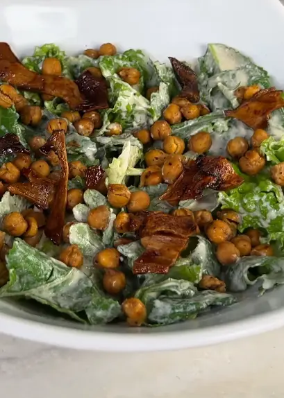 Vegan kale Caesar salad with crispy chickpeas, tempeh bacon, cherry tomatoes, and creamy tahini dressing
