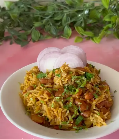 One-pot rajma rice packed in a steel lunch box with kidney beans, brown rice, spices, and fresh cilantro