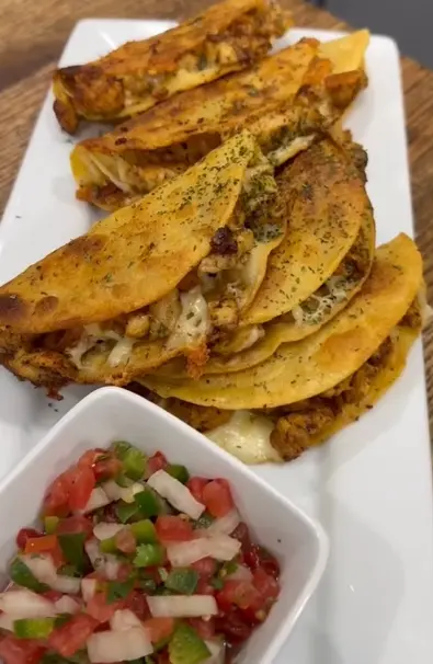 Taco-seasoned chicken pieces cooking in a skillet until browned
