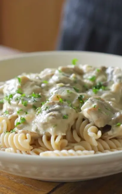 Creamy vegan mushroom stroganoff served over pasta in a bowl